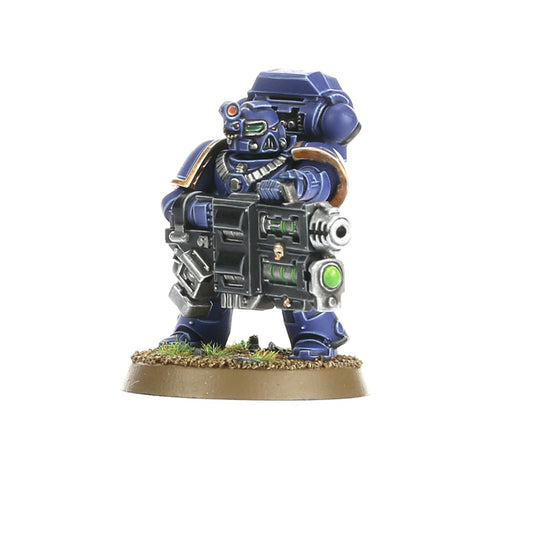 Devastator Squad Ultramarines - Devastator z multi melta widok z przodu granatowa zbroja z złotymi detalami czarna multi melta z zielonym klejnotem i srebrną lufą czerwony sensor na hełmie z zielonymi oczami złoty łańcuch na szyi brązowy naramiennik Space Marines Warhammer 40000