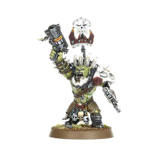 Ork Beast Snagga Nob - widok z przodu zielona skóra biała metalowa zbroja z kolcami i czerwonymi detalami szary thump gun cylindryczny z żółtymi ostrzeżeniami uniesiony w prawej ręce biała metalowa tarcza z czaszką i złotym klejnotem na kiju w lewej ręce brązowe spodnie z czaszkami przy pasie brązowa okrągła podstawka z trawą Orks Warhammer 40000