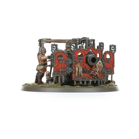 Ironweld Great Cannon wariant 2 - widok z boku na armatę z czerwonymi panelami i złotym symbolem Sigmarite, obsługiwaną przez żołnierza w hełmie z drągiem do nabijania, owalna podstawka z trawą - Warhammer Age of Sigmar