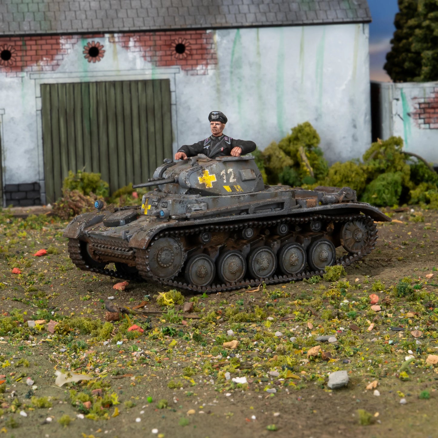 Warlord Games Panzer II – model plastikowy czołgu Panzer II w szaro-brązowym kamuflażu z żółtymi krzyżami, dowódca w czarnym mundurze, diorama 28mm Bolt Action
