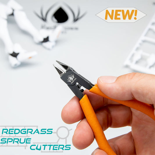 Redgrass Sprue Cutters – dłoń trzymająca nożyczki do wyprasek z pomarańczowym uchwytem, w tle figurki i wypraska, napis NEW!
