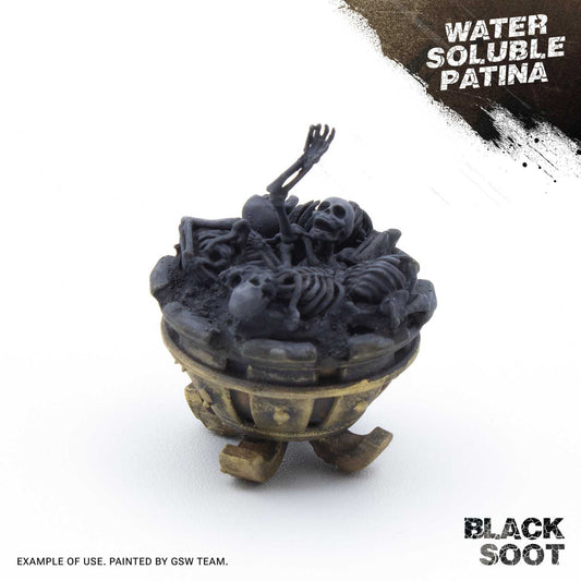 Water Soluble Patina Black Soot Green Stuff World – przykład użycia: figurka kotła ze szkieletami pokryta czarną patyną sadzy, napis "Water Soluble Patina Black Soot", przykład wykonany przez zespół GSW