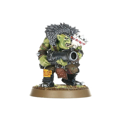 Ork Beast Snagga Boy z thump gun - widok z przodu zielona skóra szary irokiez czerwone oko biała opaska z czerwonymi trójkątami czarny thump gun z szeroką lufą trzymany oburącz żółty pas z brązową sakwą czarne spodnie brązowa okrągła podstawka z trawą Orks Warhammer 40000