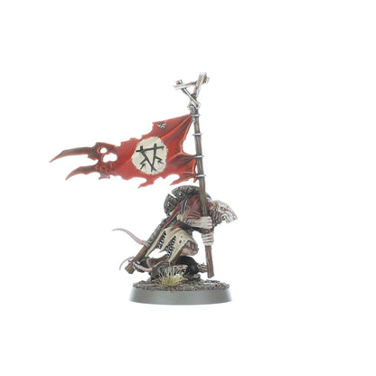 Clanrat chorąży - szczur w szaro-beżowych łachmanach trzymający czerwoną flagę z symbolem Skaven na metalowym drzewcu, różowy ogon - Warhammer Age of Sigmar