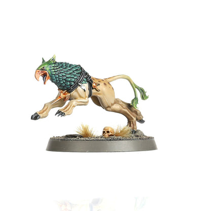 Gryph-hound beżowy - detal: beżowy gryf-pies z zieloną łuskową głową i zielonym ogonem w dynamicznym skoku z otwartym dziobem, czarne szelki z metalową klamrą, czaszka na podstawce z suchą trawą - Warhammer Age of Sigmar