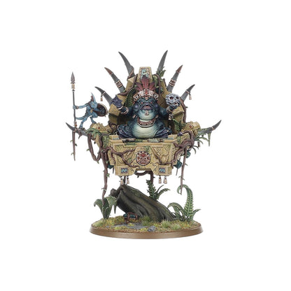 Slann Starmaster wariant 2 frontowy - ciemnozielona żaba-mag z otwartą paszczą i miedzianym pióropuszem na beżowej palankinie z azteckim symbolem, niebieski Skink ze włócznią po lewej, czarny pień na podstawce - Warhammer Age of Sigmar