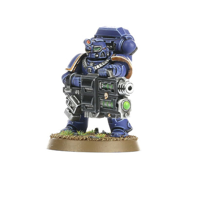 Devastator Squad Ultramarines - Devastator z multi melta widok z przodu granatowa zbroja z złotymi detalami czarna multi melta z zielonym klejnotem i srebrną lufą czerwony sensor na hełmie z zielonymi oczami złoty łańcuch na szyi brązowy naramiennik Space Marines Warhammer 40000