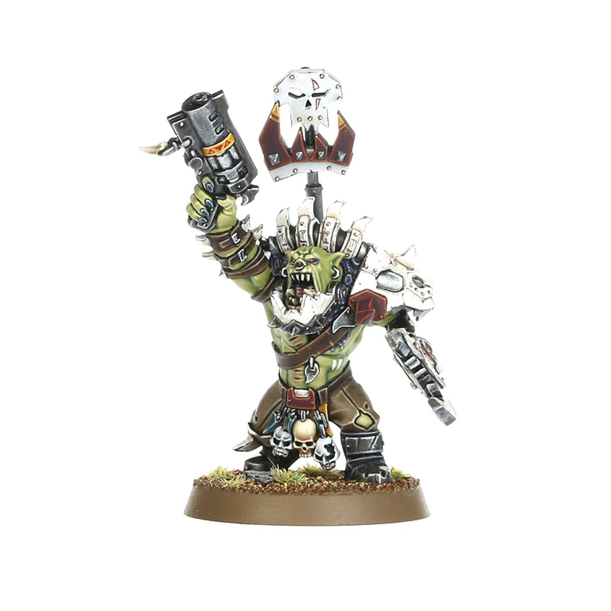 Ork Beast Snagga Nob - widok z przodu zielona skóra biała metalowa zbroja z kolcami i czerwonymi detalami szary thump gun cylindryczny z żółtymi ostrzeżeniami uniesiony w prawej ręce biała metalowa tarcza z czaszką i złotym klejnotem na kiju w lewej ręce brązowe spodnie z czaszkami przy pasie brązowa okrągła podstawka z trawą Orks Warhammer 40000
