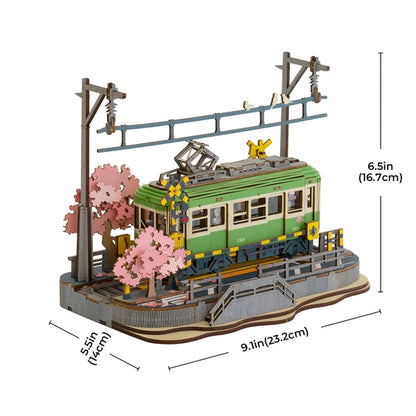 Tramwaj Sakura Journey Rolife TGS02 – zbliżenie na różowe kwiaty sakury i żółty semafor kolejowy przy torach