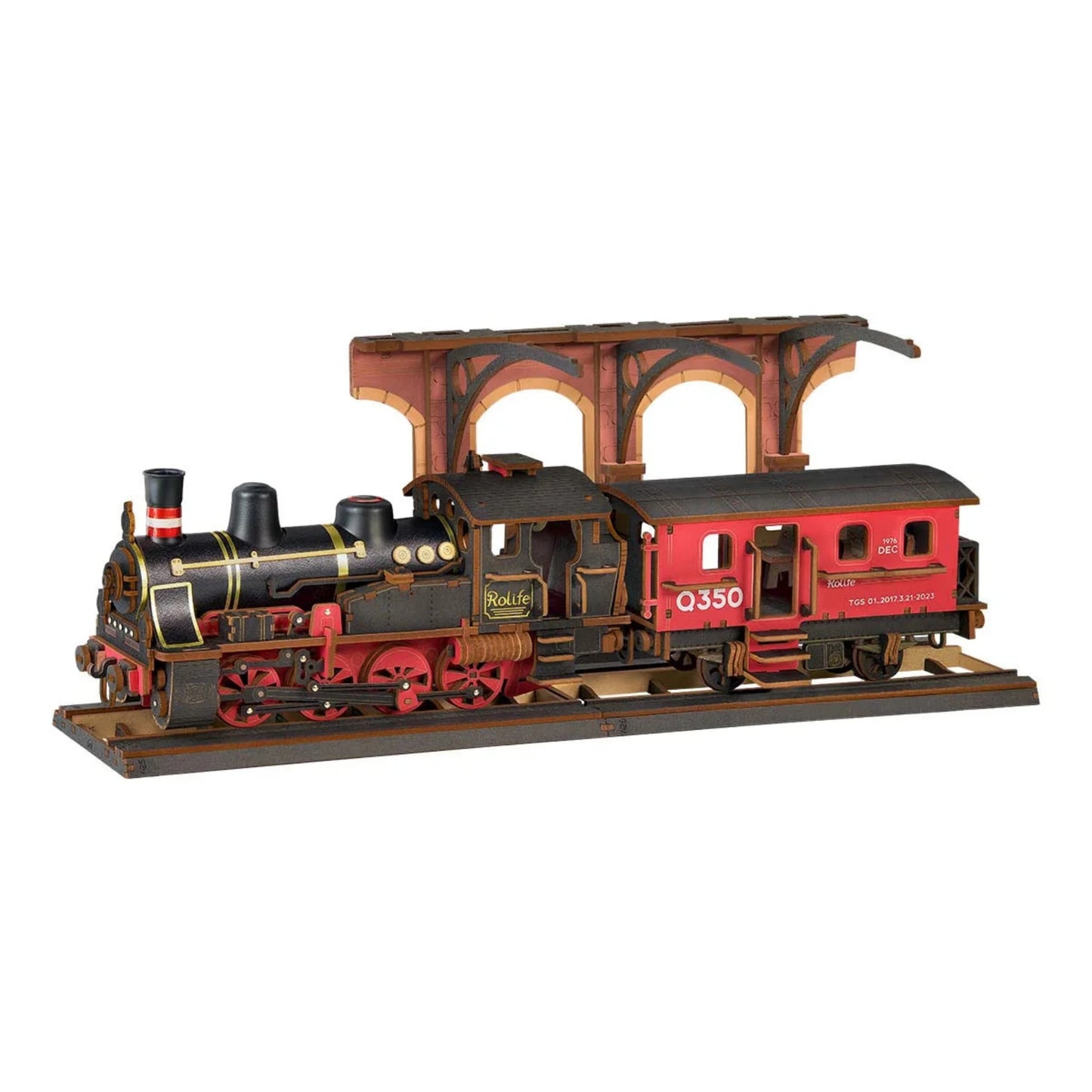 Parowóz Steam Journey Rolife TGS01 – składanie modelu: ręce trzymające czerwony wagon tramwajowy z instrukcją w tle