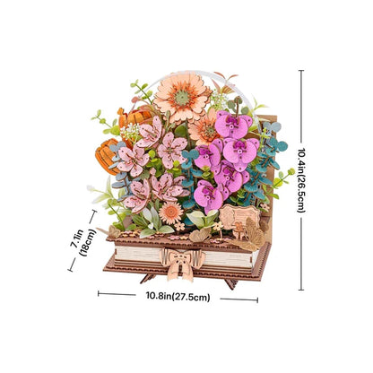 Książka w Kwiatach Wooden Blooming Book Rowood TW04H – kobieta trzymająca gotowy model z bukietem różowych i pomarańczowych kwiatów na tle ogrodu