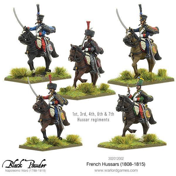 Black Powder: French Hussars 1808–1815 – pięć pomalowanych figurek huzarów konnych reprezentujących 1., 3., 4., 6. i 7. regiment huzarów w różnych kolorach mundurów z szablami uniesionymi do szarży, czarne konie na trawiastych podstawkach, logo Black Powder Napoleonic Wars, Warlord Games
