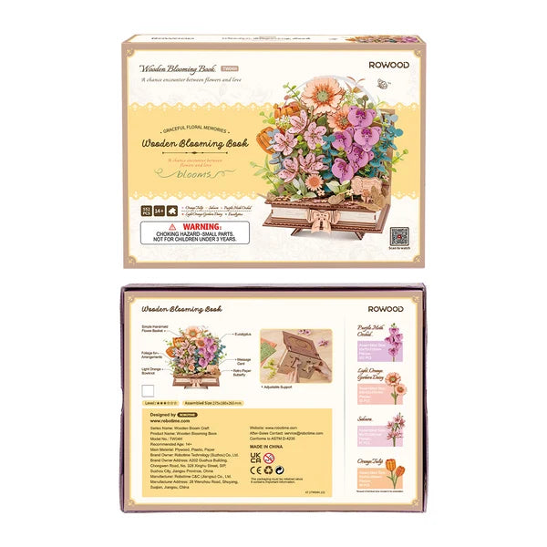 Książka w Kwiatach Wooden Blooming Book Rowood TW04H – ręka układająca kwiat do bukietu, gotowy model na stole z książkami w tle