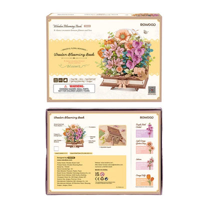 Książka w Kwiatach Wooden Blooming Book Rowood TW04H – ręka układająca kwiat do bukietu, gotowy model na stole z książkami w tle