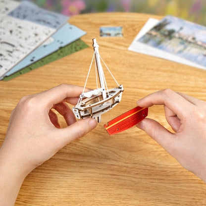 Czerwone Łodzie Red Boats Rolife TH004 – ręka układająca element puzzle na częściowo złożonym obrazie 3D na stole