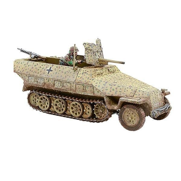 Sd.Kfz 251/10 Ausf D PaK 36 Bolt Action Warlord Games - pomalowany model 28mm półgąsienicowego transportera opancerzonego w pustynnym kamuflażu dunkelgelb z brązowymi plamami i białym krzyżem, widok z przodu z lewej, działo PaK 36 37mm na przedzie, figurka strzelca przy MG, kod 402012013