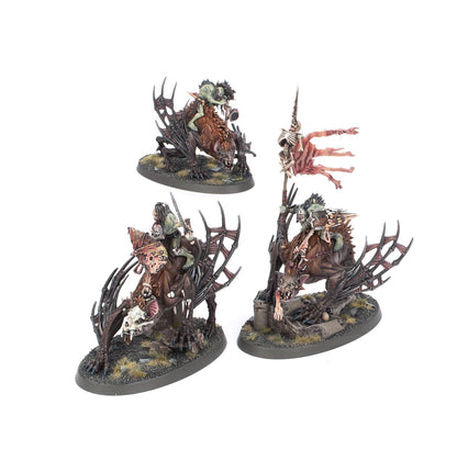 Morbheg Knights - 3 pomalowane modele Flesh-eater Courts na owalnych podstawkach z trawą: jeździec z młotem i tarczą z czaszką (górny), Champion of Morbheg z mieczem i różowym płaszczem (dolny lewy), chorąży z flagą ze skóry i szkieletem na drzewcu (dolny prawy) - Warhammer Age of Sigmar