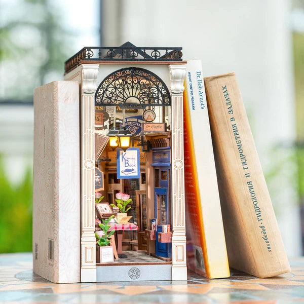 Randka w Arkadach Arcade Dating Rolife TGB10 – ręka zdejmująca osłonę przeciwkurzową z gotowego book nook, widok wnętrza z LED