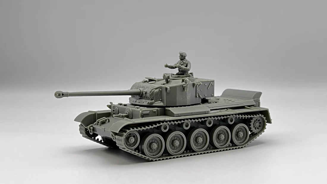 Rubicon Models 280094 A34 Comet – niezłożony model plastikowy 1/56 28mm widok z przodu-boku: szary plastik, armata 77mm HV, wieża z otwartym włazem dowódcy, figurka załogi Commonwealth, gąsienice z pełnymi ogniwami, błotniki, szare tło, Bolt Action