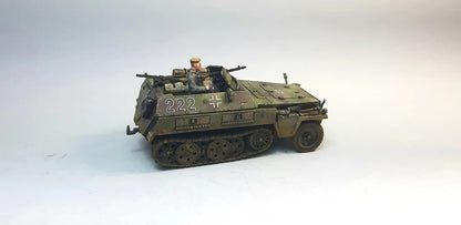 Rubicon Models 280038 SdKfz 250/1 Neu – zmontowany i pomalowany model plastikowy 1/56 28mm widok z tyłu-boku: transporter opancerzony w trójkolorowym kamuflażu (oliwkowy, brązowy, piaskowy) z numerem 222 i krzyżem żelaznym na kadłubie, figurka strzelca przy MG 34, tylne drzwi, gąsienice stalowe, białe tło, Bolt Action