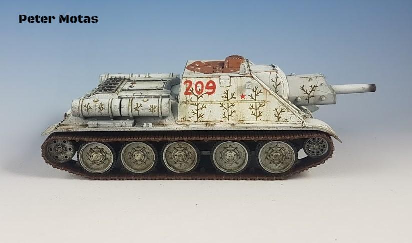 Rubicon Models 280034 SU-85 – zmontowany i pomalowany model plastikowy 1/56 28mm widok z boku: radzieckie działo samobiezne SU-85 w zimowym kamuflażu białym z numerem 209 i czerwoną gwiazdą na kadłubie, wzory gałązek, armata 85mm D-5T, gąsienice stalowe, szare tło, Bolt Action