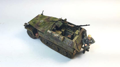 Rubicon Models 280038 SdKfz 250/1 Neu – zmontowany i pomalowany model plastikowy 1/56 28mm widok z tyłu-boku: transporter opancerzony w oliwkowym kamuflażu z numerem 222 i krzyżem żelaznym na kadłubie, figurka strzelca przy MG 34, tylne drzwi, gąsienice stalowe, białe tło, Bolt Action