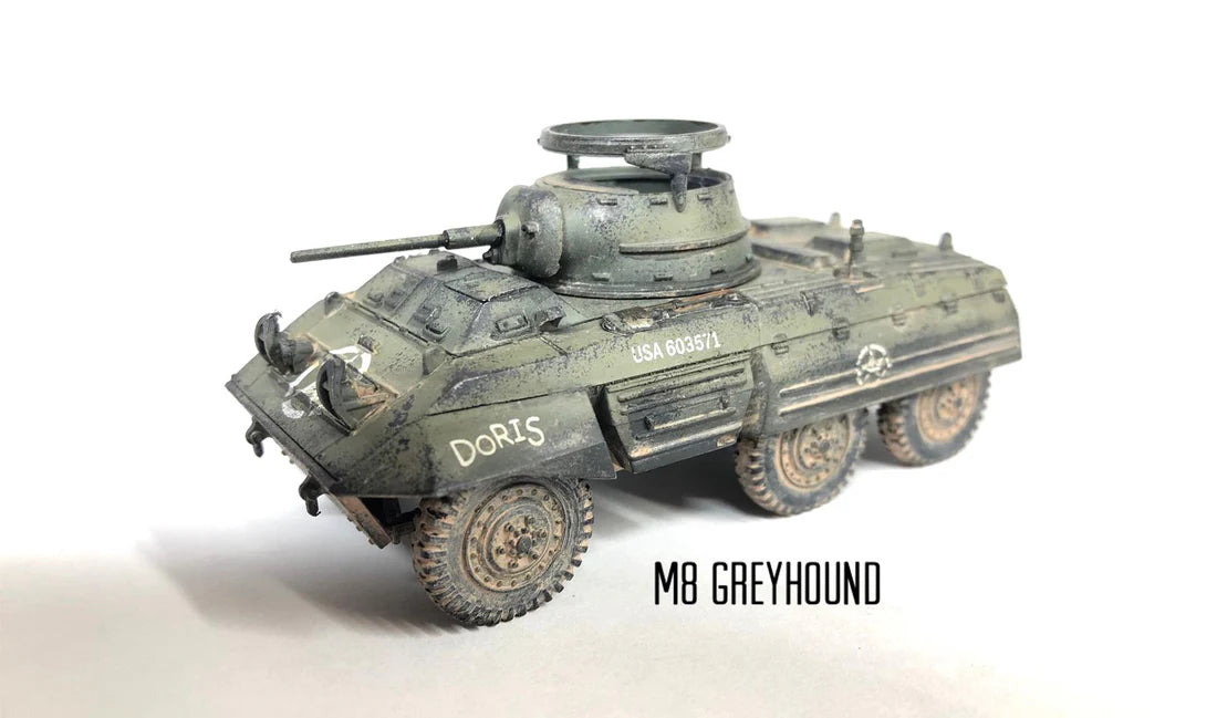 Rubicon Models 280028 M8 Greyhound – zmontowany i pomalowany model plastikowy 1/56 28mm widok z tyłu-góry: amerykański samochód pancerny w oliwkowej zieleni z numerem USA 603570 na kadłubie, armata 37mm M6 w wieży, pierŜień MG, koła terenowe 6x6, napis M8 GREYHOUND, białe tło, Bolt Action