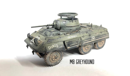 Rubicon Models 280028 M8 Greyhound – zmontowany i pomalowany model plastikowy 1/56 28mm widok z tyłu-góry: amerykański samochód pancerny w oliwkowej zieleni z numerem USA 603570 na kadłubie, armata 37mm M6 w wieży, pierŜień MG, koła terenowe 6x6, napis M8 GREYHOUND, białe tło, Bolt Action