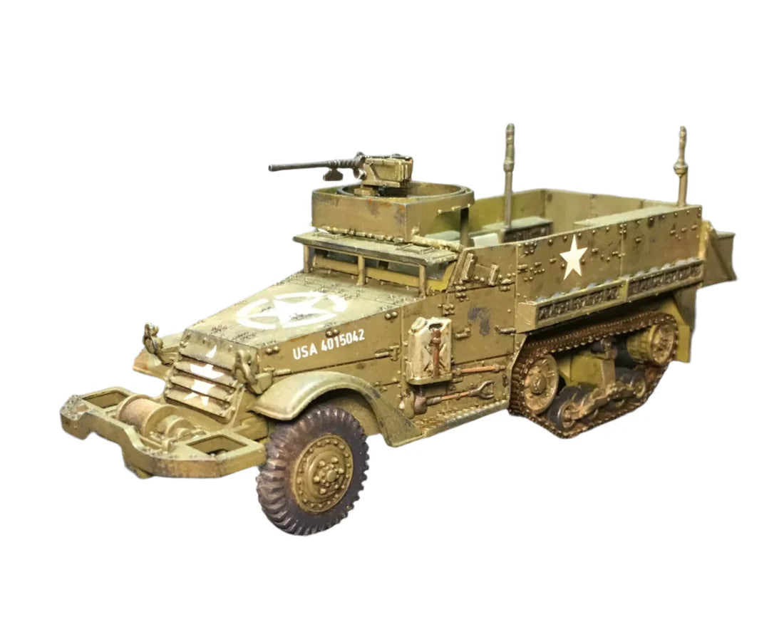 Rubicon Models 280027 M3 / M3A1 Half-Track – zmontowany i pomalowany model plastikowy 1/56 28mm widok z boku-przodu: amerykański transporter półgąsienicowy M3A1 w oliwkowej zieleni z białą gwiazdą i numerem USA 4068914 na kadłubie, karabin maszynowy M2HB na pierścieniu, tylne stojaki bagażowe, gąsienice stalowe, koła przednie, białe tło, Bolt Action