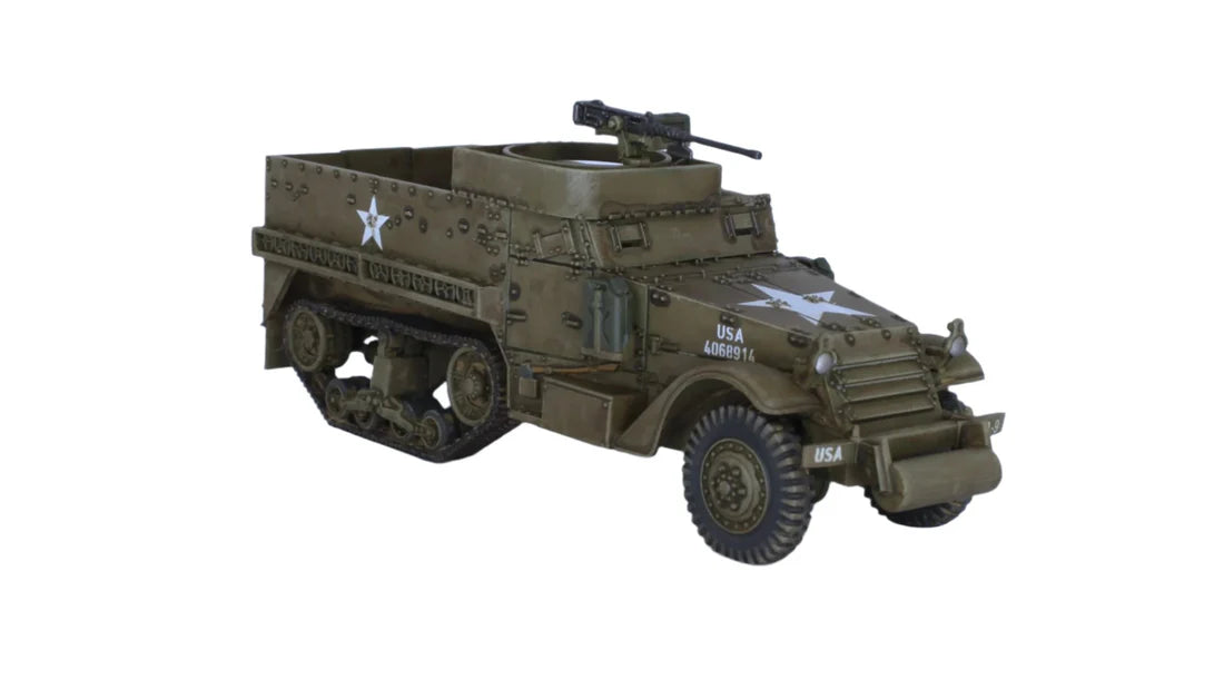 Rubicon Models 280027 M3 / M3A1 Half-Track – zmontowany i pomalowany model plastikowy 1/56 28mm widok z boku-przodu: amerykański transporter półgąsienicowy M3A1 w oliwkowej zieleni z białą gwiazdą i numerem USA C109276 na kadłubie, figurki żołnierzy US Army, karabin maszynowy M2HB na pierścieniu, gąsienice stalowe, koła przednie, białe tło, Bolt Action