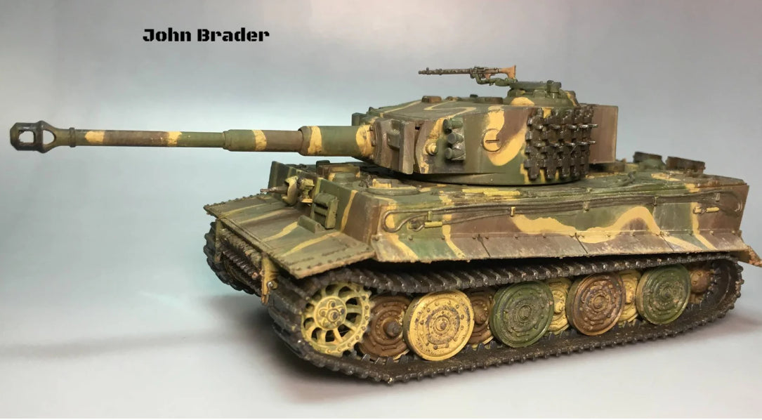 Rubicon Models 280016 Tygrys I Ausf. E – zmontowany i pomalowany model plastikowy 1/56 28mm widok z boku-przodu: czołg ciężki Tygrys I w trójkolorowym kamuflażu (oliwkowy, brązowy, piaskowy) z krzyżem żelaznym na kadłubie, armata KwK 36 L/56 kal. 88mm, filtry Feifel, gąsienice stalowe, szare tło, Bolt Action, John Brader