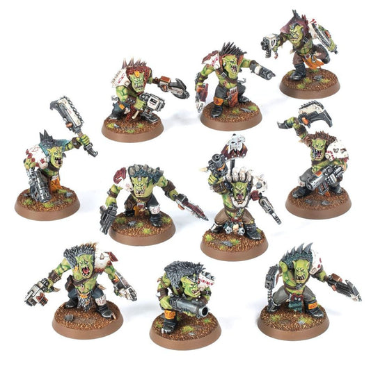 Ork Beast Snagga Boyz - widok grupowy 10 modeli zielona skóra brązowo-czarne kombinezony i zbroje: górny rząd lewy z białą piłą łańcuchową i szarym pistoletem; górny środkowy z czerwonym irokiezem i szarym pistoletem; górny prawy z szarym pistoletem uniesionym; prawy środkowy z białą zbroją i szarym pistoletem; środkowy z szarym nożem; środkowy z czarnym działem i białą czaszką na kiju; lewy środkowy z szarym pistoletem i czarnym plecakiem; dolny lewy z białą zbroją i szarym pistoletem; dolny środkowy z sza