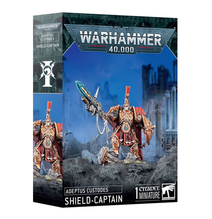 Shield-Captain Adeptus Custodes - pudełko Warhammer 40000 Adeptus Custodes niebiesko-złote 1 Citadel Miniature Shield-Captain z Pyrithite Spear i Praesidium Shield szare ruiny tło Games Workshop