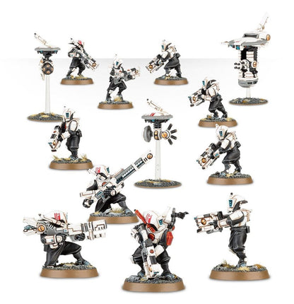 T'au Pathfinder Team - widok grupowy 10 Pathfinderów biała zbroja czarne kombinezony rail rifle ion rifle pulse carbine 3 drony brązowe podstawki Warhammer 40000