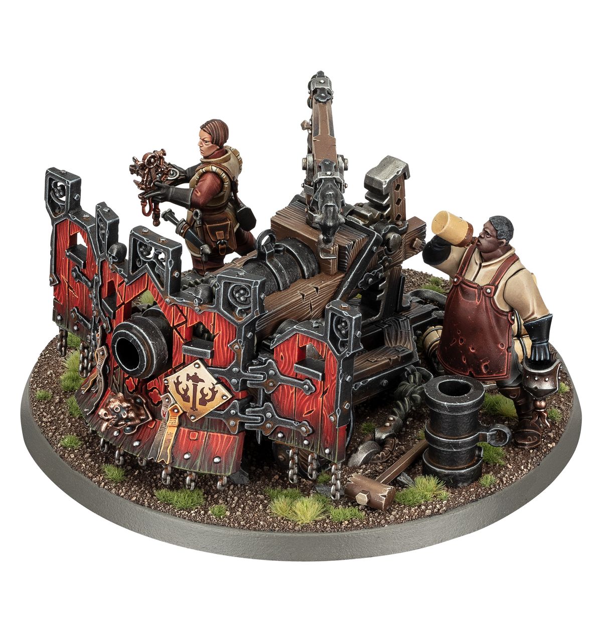 Ironweld Great Cannon - masywna armata Cities of Sigmar na drewnianej platformie z czerwonymi panelami i czarnymi metalowymi okuciami, obsługiwana przez kobietę w brązowym stroju z narzędziami i mężczyznę w czerwonym fartuchu wkładającego ładunek, owalna podstawka z piaskiem i trawą - Warhammer Age of Sigmar
