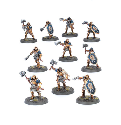 Liberators - 10 modeli Stormcast Eternals w złoto-brązowej zbroi z niebieskimi naramiennikami, młoty i tarcze z symbolem Sigmara, warianty z hełmem i bez hełmu, różne dynamiczne pozy - Warhammer Age of Sigmar