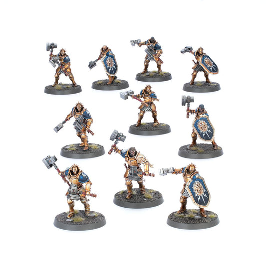 Liberators - 10 modeli Stormcast Eternals w złoto-brązowej zbroi z niebieskimi naramiennikami, młoty i tarcze z symbolem Sigmara, warianty z hełmem i bez hełmu, różne dynamiczne pozy - Warhammer Age of Sigmar