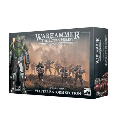Veletaris Storm Section - pudełko Warhammer The Horus Heresy Solar Auxilia ciemnoszare ilustracja 10 Veletarii szturmujących przez błotniste ruiny z vexilla w tle duży Vox Operator w zielonej void armour 10 Citadel Miniatures Games Workshop