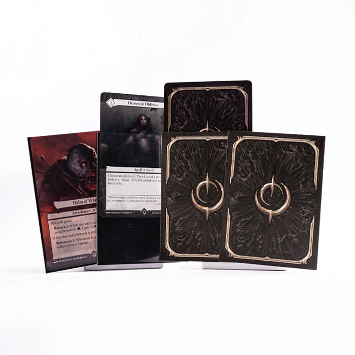 Malediction Card Sleeve – 2 koszulki z ciemnym ornamentem i złotym symbolem Malediction obok kart Helm of Wrath i Drown in Oblivion na białym tle