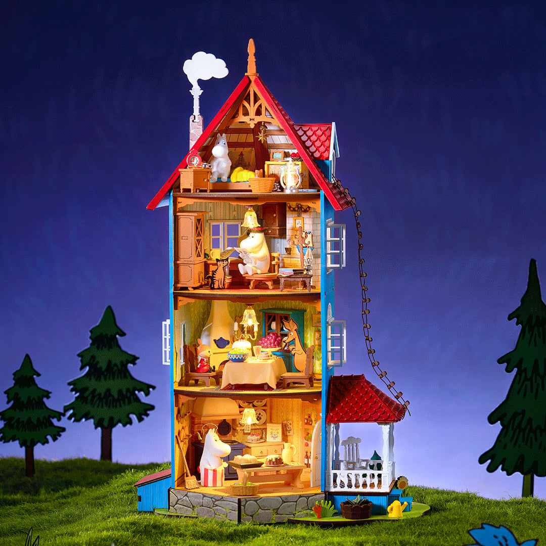 Dom Muminków Rolife DA009 Moominhouse – zbliżenie na kondygnację z Tatusiem Muminkiem czytającym gazetę w cylindrze, kotem i meblami drewnianymi