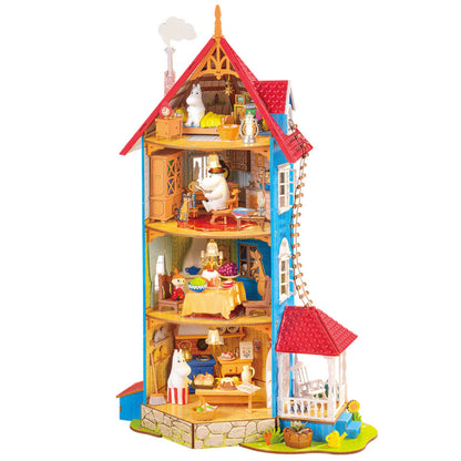 Dom Muminków Rolife DA009 Moominhouse – gotowy model na tle bajkowego krajobrazu, widok z przodu z otwartą fasadą i wnętrzem 4 kondygnacji z figurkami Muminków