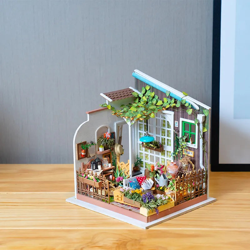 Kwiaciarnia Millera Miller's Flower House Rolife DG108 – gotowy model w ciepłym świetle wieczornym z otwartymi drzwiami i bujną roślinnością