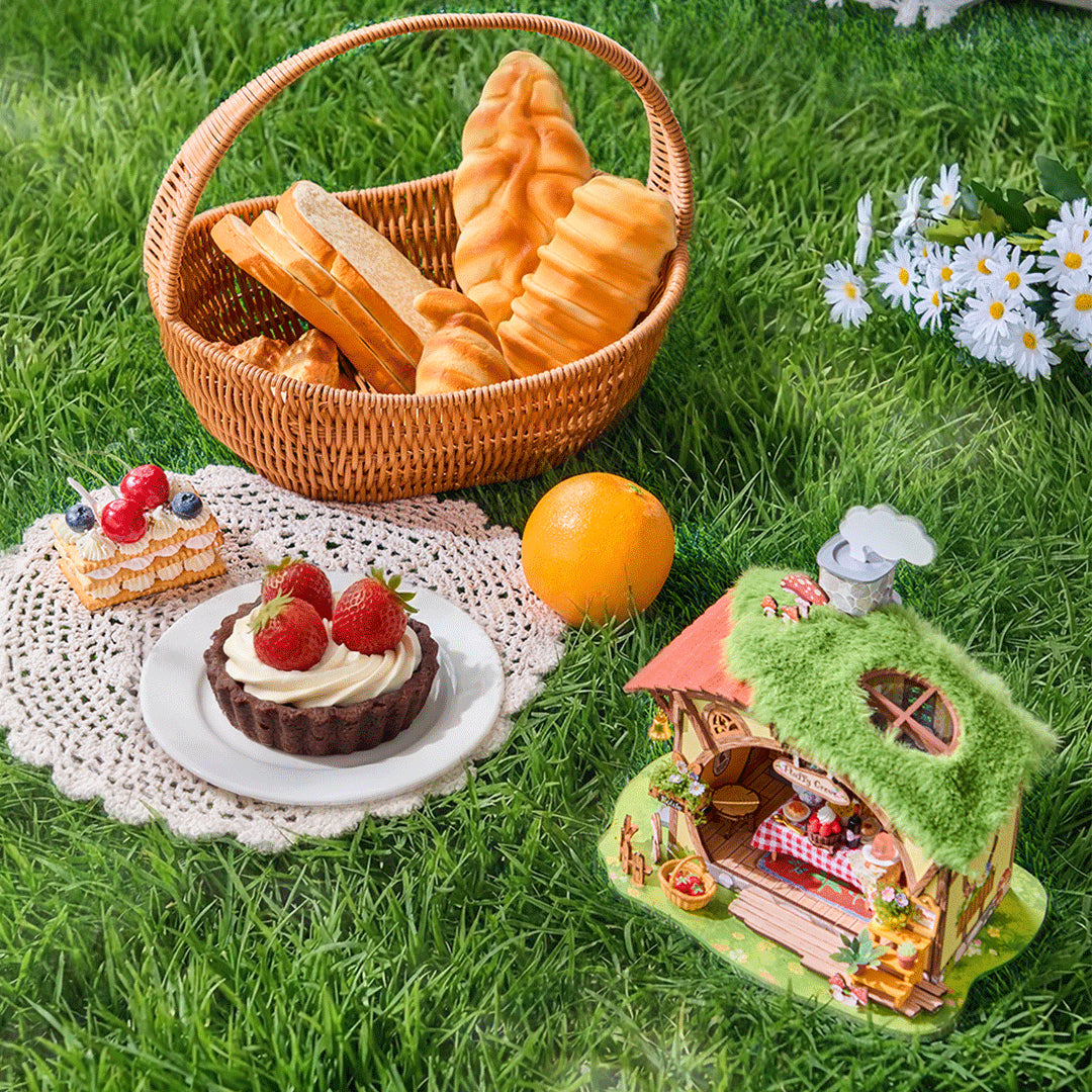 Leśna Chatka Fluffy Grove Rolife DG184 – gotowy model na łące obok koszyka z pieczywem, tartami i stokrotkami, widok lifestyle