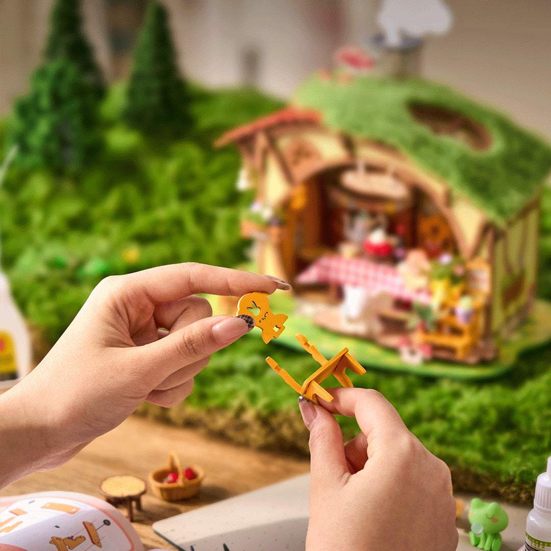Leśna Chatka Fluffy Grove Rolife DG184 – cztery modele z serii w gablotach na komodzie w salonie: Fluffy Grove, szklarnia, dom A-frame i cieplarnia