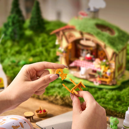 Leśna Chatka Fluffy Grove Rolife DG184 – cztery modele z serii w gablotach na komodzie w salonie: Fluffy Grove, szklarnia, dom A-frame i cieplarnia