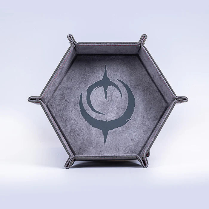 Malediction Premium Dice Tray – sześciokątna taca na kości rozłożona, widok frontalny: ciemnoszara zamszowa powierzchnia z dużym logo Malediction i srebrne zatrzaśki na jasnym tle