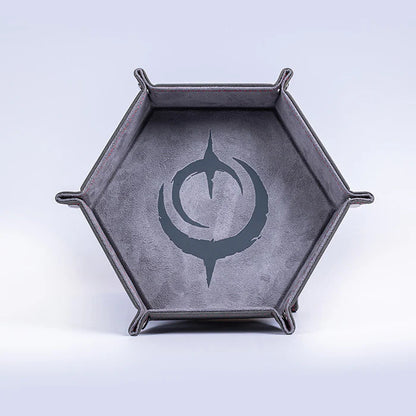 Malediction Premium Dice Tray – sześciokątna taca na kości rozłożona, widok frontalny: ciemnoszara zamszowa powierzchnia z dużym logo Malediction i srebrne zatrzaśki na jasnym tle