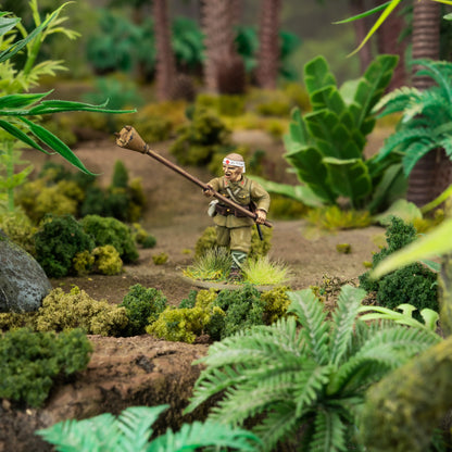 Bolt Action For the Emperor! 402616025 – pomalowana plastikowa figurka japońskiego żołnierza piechoty 28mm z lunge mine (mina na tyczce) w mundurze khaki z białą opaską na głowie, na tle dżungli z paprociami, Warlord Games
