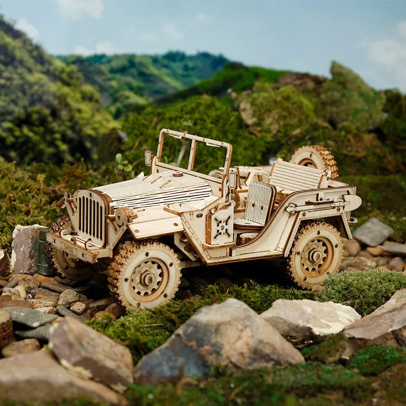 Wojskowy Jeep ROKR MC701 Army Field Car – gotowy model na skałach i mchu w terenie, widok z przodu z widoczną kratką chłodnicy i reflektorami