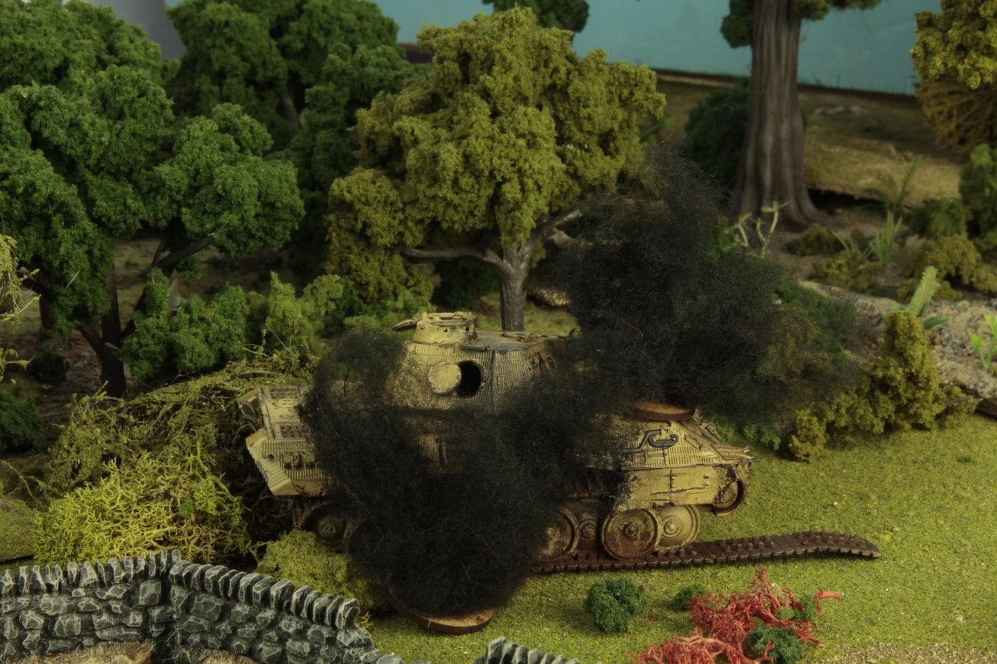Tank Damage Markers Bolt Action – zbliżenie na płonący model lekkiego czołgu z efektem ognia i czarnego dymu na stole do gry
